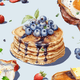 Decorative illustration of pancakes with blueberries and syrup